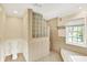 Well-lit bathroom featuring a tub, a shower, and tiled walls at 9650 Copley Dr, Carmel, IN 46290