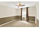 Two-tone bedroom with carpeted floors, ceiling fan and a window dressed with curtains at 9650 Copley Dr, Carmel, IN 46290