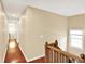 Upper level hallway with hardwood flooring, and access to the bedrooms with a natural light at 9650 Copley Dr, Carmel, IN 46290