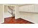 Hallway with hardwood flooring leads to carpeted stairs and features built-in cabinets along the wall at 9650 Copley Dr, Carmel, IN 46290