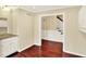 Hallway with rich hardwood flooring, leading to stairs with access to upper level and cabinets on right at 9650 Copley Dr, Carmel, IN 46290