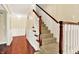 Carpeted staircase featuring wood trim, white spindles, and view of the entry with decorative wall paneling at 9650 Copley Dr, Carmel, IN 46290
