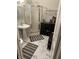 Bright bathroom features a pedestal sink, glass shower, and stylish dark wood storage cabinet at 1002 N New Jersey St, Indianapolis, IN 46202