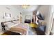 Spacious bedroom featuring hardwood floors, a ceiling fan, and a large bed with colorful patterned blanket at 1002 N New Jersey St, Indianapolis, IN 46202