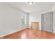 Bedroom featuring wood floors, a window for light, and access to a closet at 1020 N Ritter Ave, Indianapolis, IN 46219