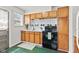 Functional kitchen features wood cabinets, stainless steel sink, and a black range at 1020 N Ritter Ave, Indianapolis, IN 46219