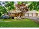 Charming brick home featuring a well-manicured lawn, mature trees, and an attached three car garage at 1065 E 76Th St, Indianapolis, IN 46240