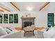 Living room featuring a stone fireplace, hardwood floors, wooden ceiling beams, and abundant natural light at 1065 E 76Th St, Indianapolis, IN 46240