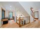 Hallway with wood floors, wood railing, and desk area with natural lighting at 1065 E 76Th St, Indianapolis, IN 46240