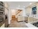 Modern kitchen showcasing stainless steel appliances, custom cabinetry, and stone floors, conveniently located near the staircase at 1065 E 76Th St, Indianapolis, IN 46240