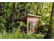 Small wood outbuilding surrounded by lush greenery, providing a serene and secluded space at 1065 E 76Th St, Indianapolis, IN 46240
