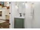 Stylish powder room featuring a green vanity, modern sink, and decorative lighting fixtures at 1065 E 76Th St, Indianapolis, IN 46240