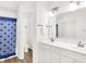 Bright bathroom features double sinks with new fixtures, white cabinets, and a blue shower curtain at 10712 Cardinal Cir, Indianapolis, IN 46231