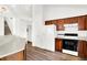 Kitchen with white refrigerator and stove, adjacent to the staircase, showcasing an efficient layout at 10712 Cardinal Cir, Indianapolis, IN 46231