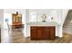 Kitchen cabinets with wood floor looking into a dining room with a table, chairs, and staircase at 10712 Cardinal Cir, Indianapolis, IN 46231