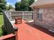 Exterior view of back deck shows worn, red painted surface and wood fence at 1082 E County Road 400 S, Clayton, IN 46118