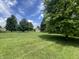 Picturesque backyard with mature trees, offering shade and a classic shed in the distance at 1082 E County Road 400 S, Clayton, IN 46118