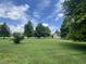 Expansive backyard with mature trees offering shade and a vintage shed at the back of the property at 1082 E County Road 400 S, Clayton, IN 46118