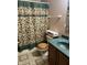 Bathroom includes floral shower curtain, green counter and matching tile flooring at 1082 E County Road 400 S, Clayton, IN 46118