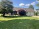 Ranch-style home with large front yard, mature tree, and a two-car garage at 1082 E County Road 400 S, Clayton, IN 46118