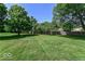 Expansive backyard featuring a lush lawn and mature trees, creating a private oasis at 11030 Brentwood Ave, Zionsville, IN 46077