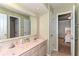 Well lit bathroom with a double sink and vanity with a view to the connected bedroom at 11030 Brentwood Ave, Zionsville, IN 46077