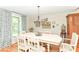 A spacious dining room is brightly lit by a light fixture and the sunlight streaming in through the window at 11030 Brentwood Ave, Zionsville, IN 46077