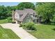 Beautiful home with a stone and siding exterior, complemented by a mature tree and a well-manicured lawn at 11030 Brentwood Ave, Zionsville, IN 46077