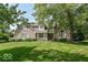 Charming brick home featuring lush landscaping, mature trees, and well-maintained lawn at 11030 Brentwood Ave, Zionsville, IN 46077