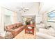 A brightly-lit living room boasts soaring ceilings, a ceiling fan, and a cozy seating arrangement at 11030 Brentwood Ave, Zionsville, IN 46077