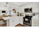 Updated kitchen with stainless steel appliances, white cabinets, and a convenient breakfast bar at 11518 Cherry Blossom W Dr, Fishers, IN 46038