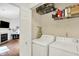 Bright laundry room with white washer and dryer, open shelving for storage, and easy access at 11518 Cherry Blossom W Dr, Fishers, IN 46038