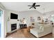 Bright living room with a fireplace, fan, and hardwood floors at 11518 Cherry Blossom W Dr, Fishers, IN 46038
