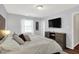 Inviting bedroom featuring natural light, dark wood dresser, and large television at 11518 Cherry Blossom W Dr, Fishers, IN 46038