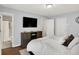 Bright bedroom featuring hardwood floors, TV, dresser, and adjacent bathroom at 11518 Cherry Blossom W Dr, Fishers, IN 46038