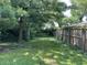 Large backyard enclosed by a wooden fence, featuring mature trees for shade and privacy at 1206 Lincoln St, Shelbyville, IN 46176