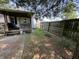 A grassy backyard features a weathered wooden fence and a covered patio area on the side of the house at 1206 Lincoln St, Shelbyville, IN 46176