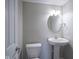 Powder room with pedestal sink, round mirror with decorative light fixture, and painted walls at 1278 W Limestone Way, Fortville, IN 46040