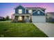 Charming two-story home at dusk featuring a well-manicured lawn and a two-car garage at 1278 W Limestone Way, Fortville, IN 46040
