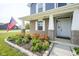 Charming brick front porch with vibrant flower garden and American flag at 1278 W Limestone Way, Fortville, IN 46040