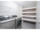 Laundry room with gray wood-look floor, wire rack, open shelves and front load washer and dryer at 1278 W Limestone Way, Fortville, IN 46040