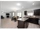 Open kitchen with stainless steel appliances, island seating, and a seamless flow to the dining area at 1312 Donald Pass, Greenwood, IN 46143