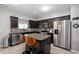 Modern kitchen with stainless steel appliances, island seating, and sleek, dark cabinetry at 1312 Donald Pass, Greenwood, IN 46143