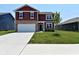 Charming two-story home boasting well-maintained landscaping and an inviting two-car garage at 1351 Byron St, Greenfield, IN 46140