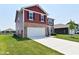 Charming two-story home featuring stone accents, a two-car garage, and a well-manicured lawn at 1351 Byron St, Greenfield, IN 46140