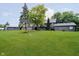Spacious backyard with a lush green lawn, mature trees, and a detached garage and shed at 16714 Oak Rd, Westfield, IN 46074