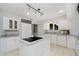 Well-lit kitchen with white cabinets, modern appliances, and a cooktop island at 16714 Oak Rd, Westfield, IN 46074