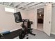 Finished basement featuring exercise bike, painted floor and view of another room at 1702 Kessler Blvd E Dr, Indianapolis, IN 46220