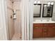 Updated bathroom featuring tiled shower and double sink vanity with framed mirrors and neutral wall color at 1702 Kessler Blvd E Dr, Indianapolis, IN 46220