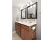 Bright bathroom featuring double sinks, wooden cabinets, and framed mirrors with modern lighting fixtures at 1702 Kessler Blvd E Dr, Indianapolis, IN 46220